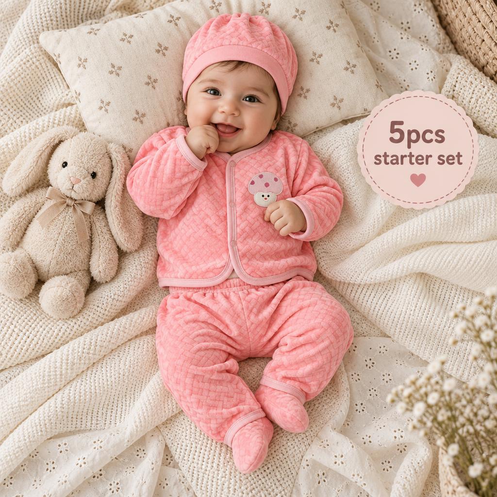 Pink newborn 5-piece quilted bear starter set worn by a baby, highlighting the pink bear chest patch top, matching quilted trouser and coordinating cap.