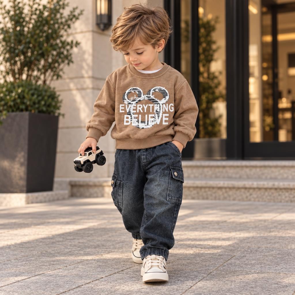 Boy wearing the Brown mouse graphic sweatshirt and dark denim-look cargo baggy pants, with everything-believe front wording visible.