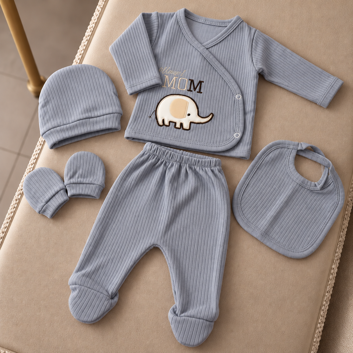 Grey ribbed 5-piece newborn starter set arranged on a chair, featuring the embroidered-look Mom wording and elephant applique on the wrap top.