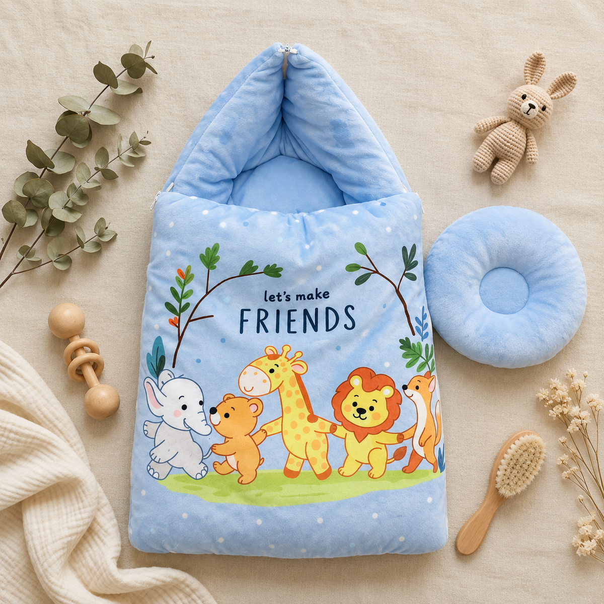Blue baby carry nest with a matching round pillow, shown flat on a neutral nursery backdrop with colourful Friends animal artwork on the front.