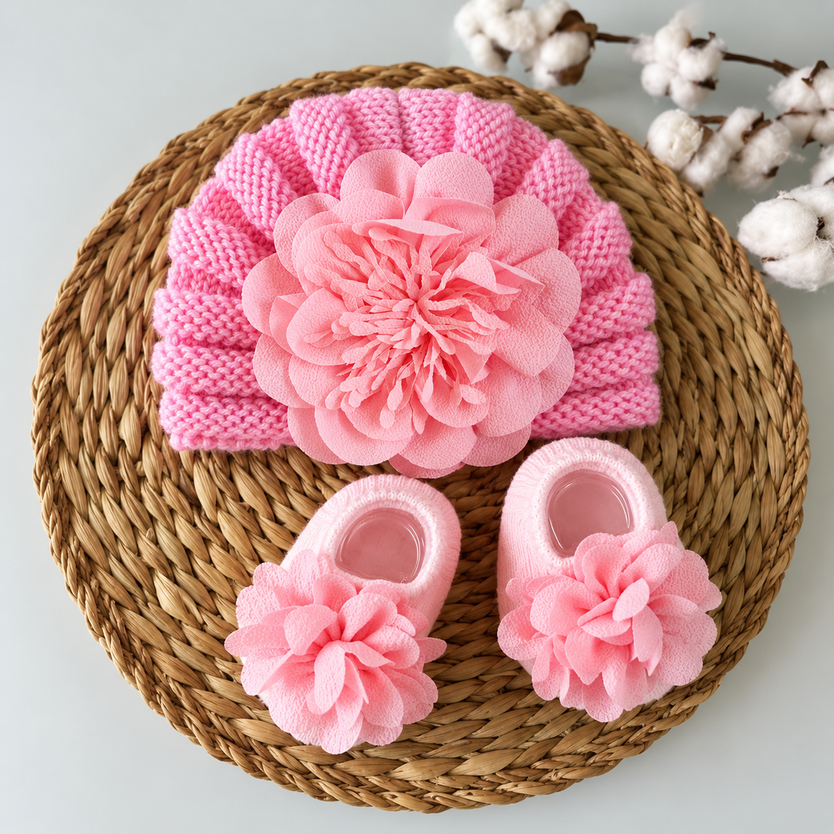 Light Pink baby turban cap and matching socks 2-piece set displayed on a woven mat with oversized layered Pink floral appliques.