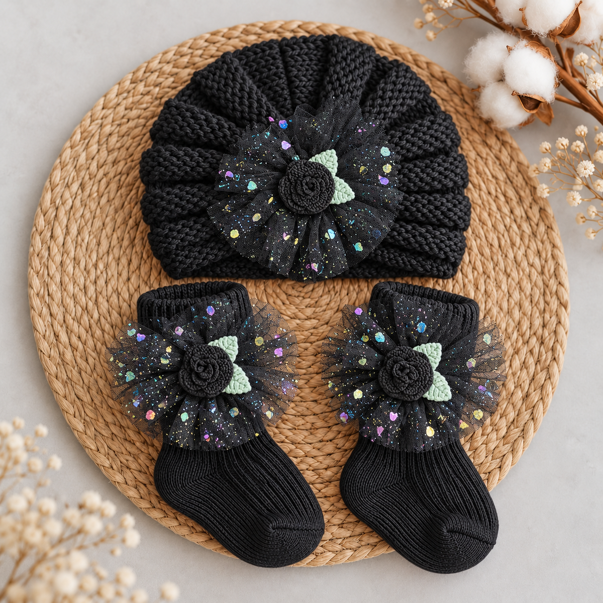 Black baby gathered turban cap and matching ankle socks set with black rose appliques, green leaves and colourful reflective dotted tulle flowers.