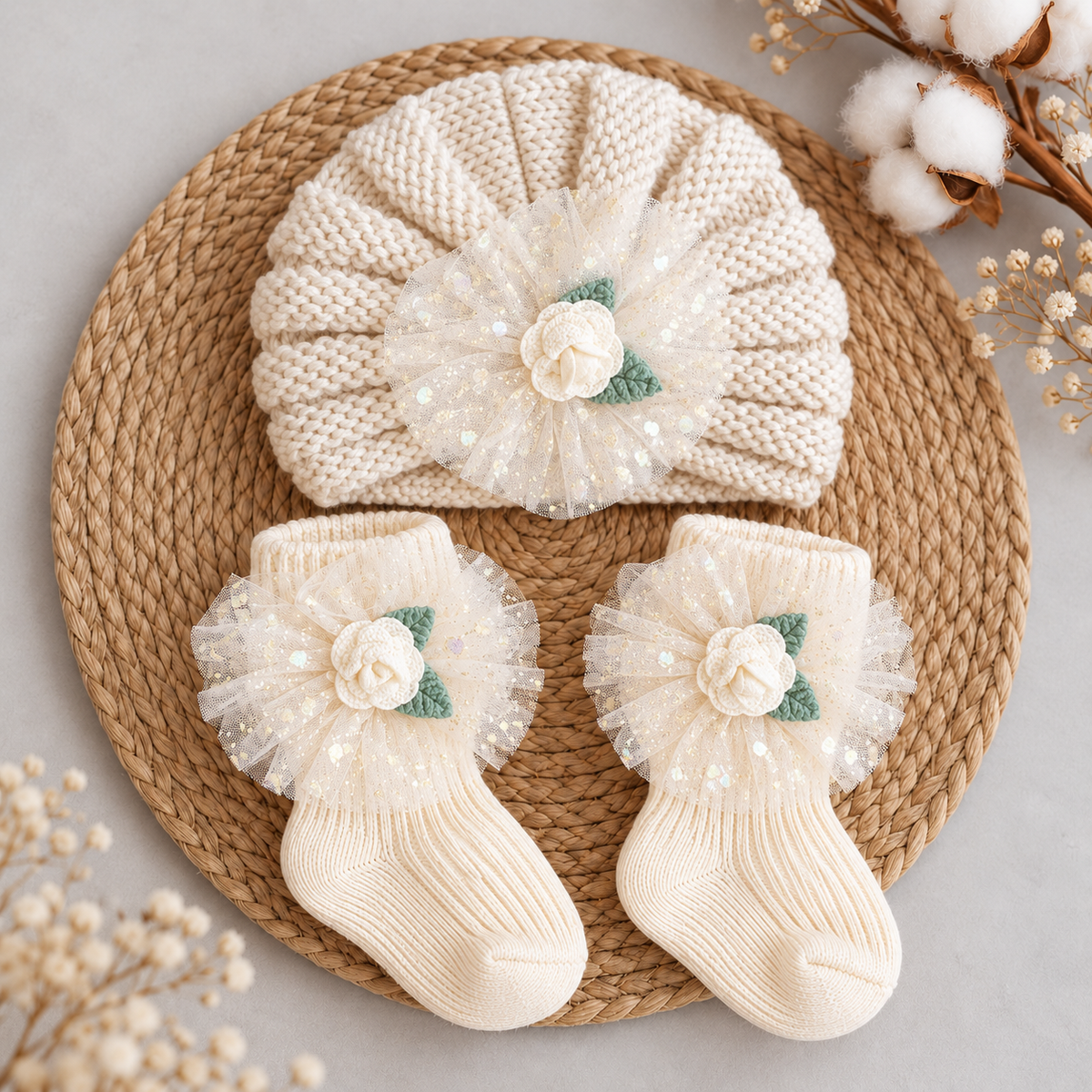 Cream baby textured turban cap and matching ankle socks set displayed flat, featuring sheer dotted tulle flowers, cream rose appliques and green leaves.