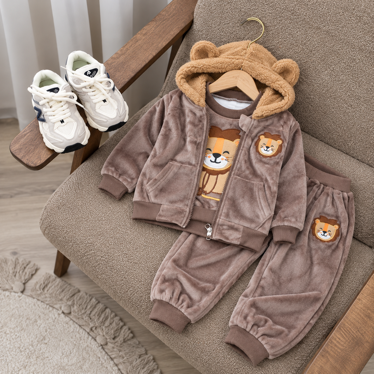 Light Brown kids 3-piece velvet suit displayed on a chair, featuring a teddy-ear hooded zip jacket, bear-print shirt and matching bear-patch cuffed trousers.
