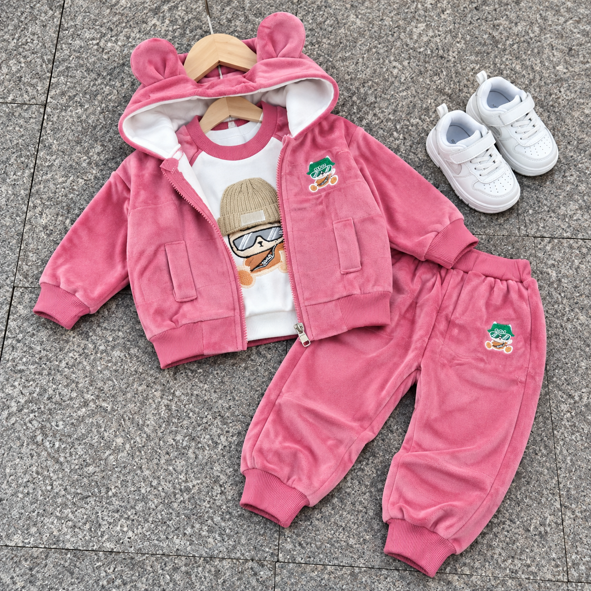 Pink kids velvet 3-piece suit laid flat with bear-ear hooded zip jacket, character-print White shirt and matching cuffed trousers.