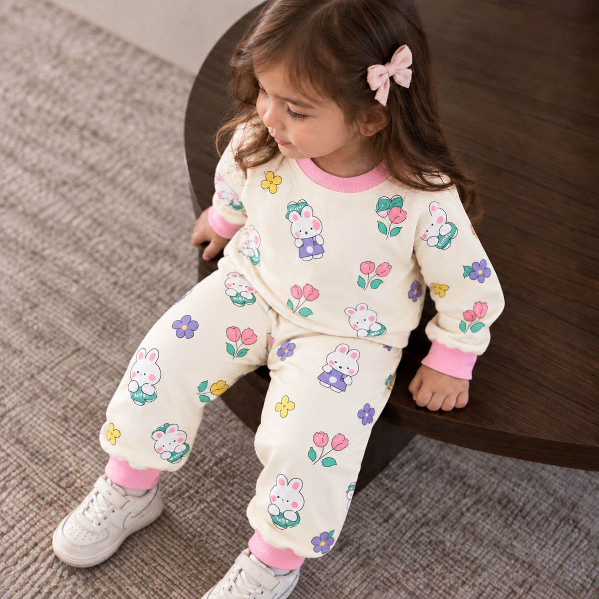 Toddler girl wearing the Cream bunny and flower print shirt and trouser set with Pink ribbed neckline, cuffs and ankle trims.