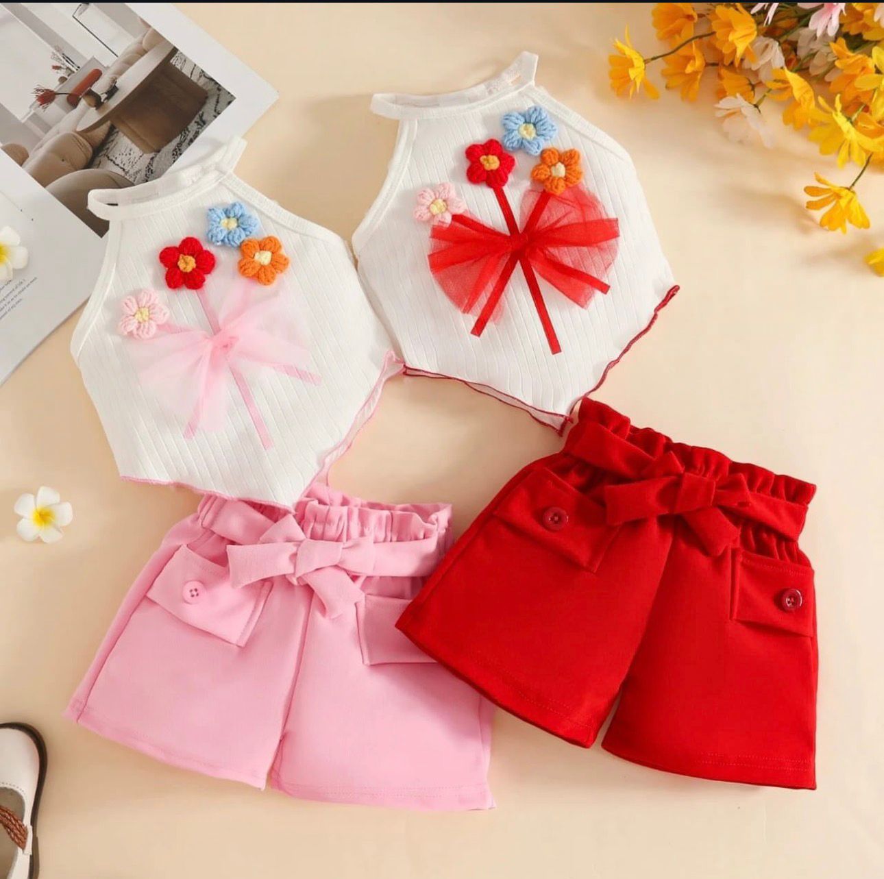 Children's outfit with floral and bow details on a beige background