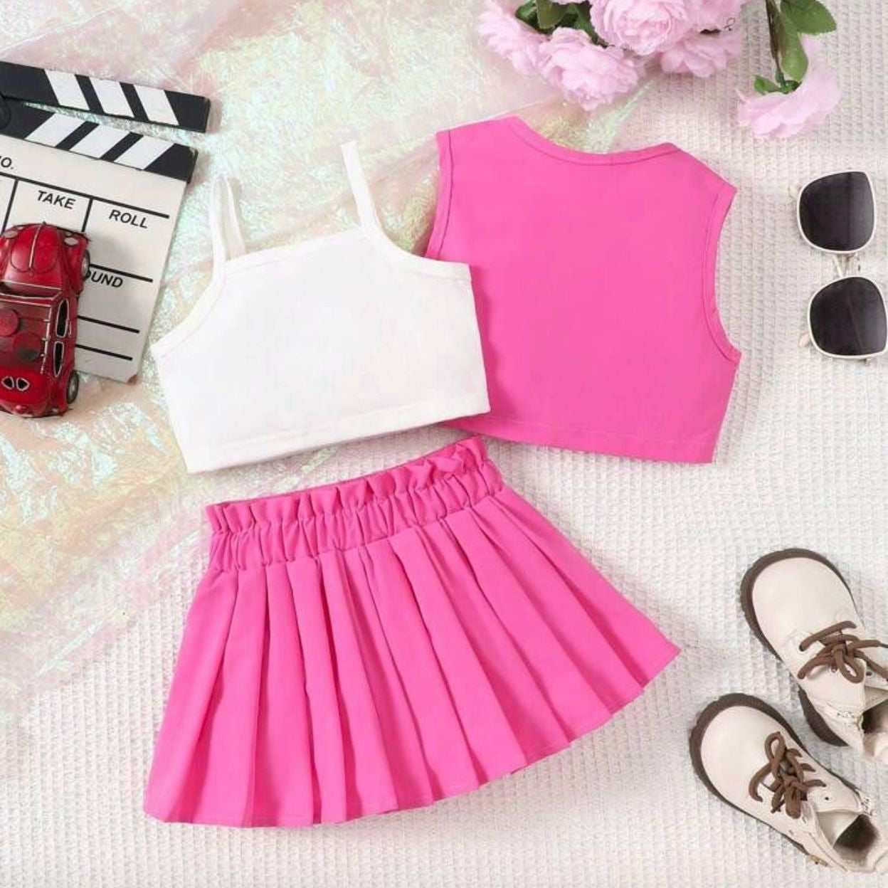 Pink and white outfit with accessories on a textured surface