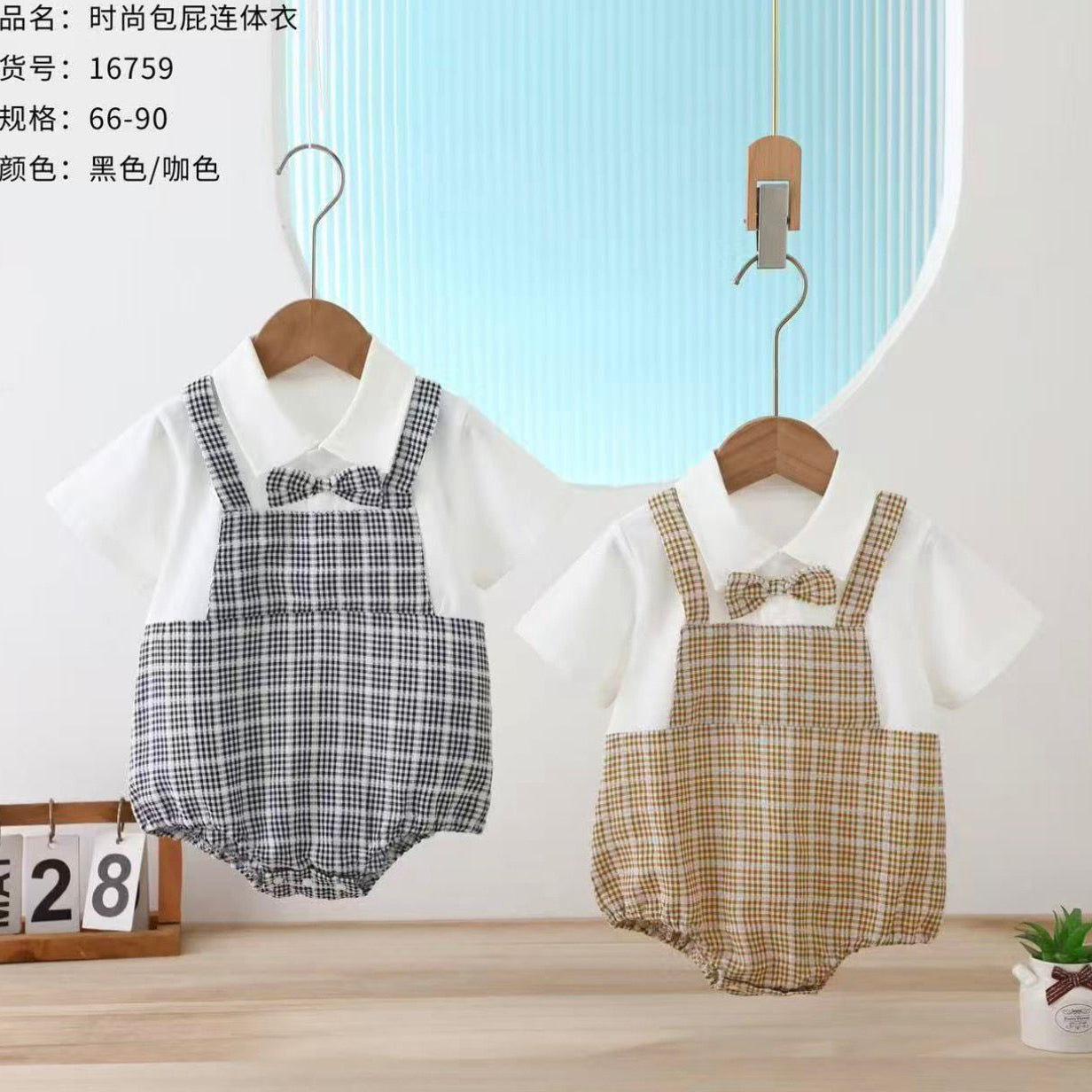 Two baby rompers with plaid patterns on hangers against a light blue wall.