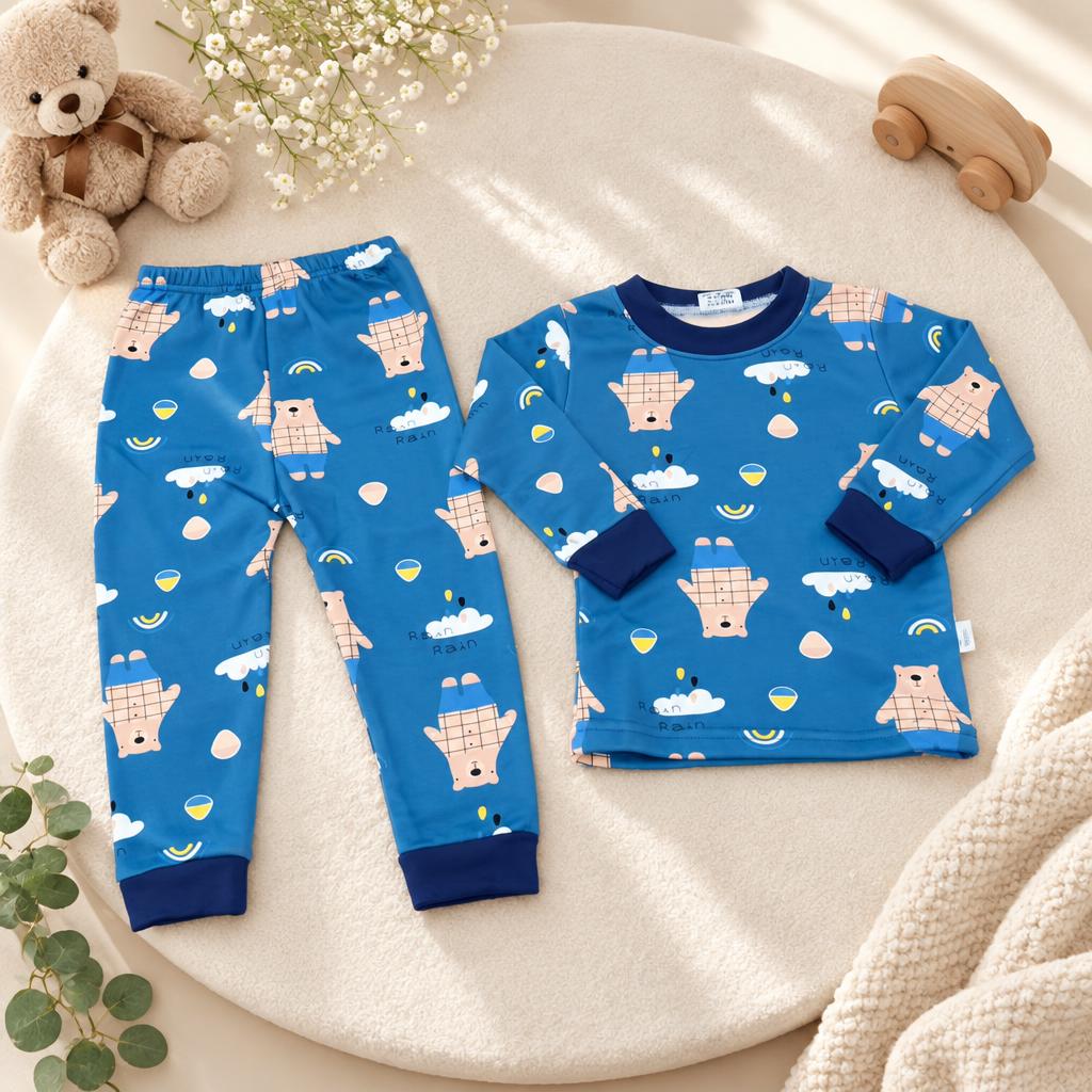 Blue checked bear, cloud and rainbow print long-sleeve shirt with matching trousers, arranged in a styled flat lay with navy cuffs.