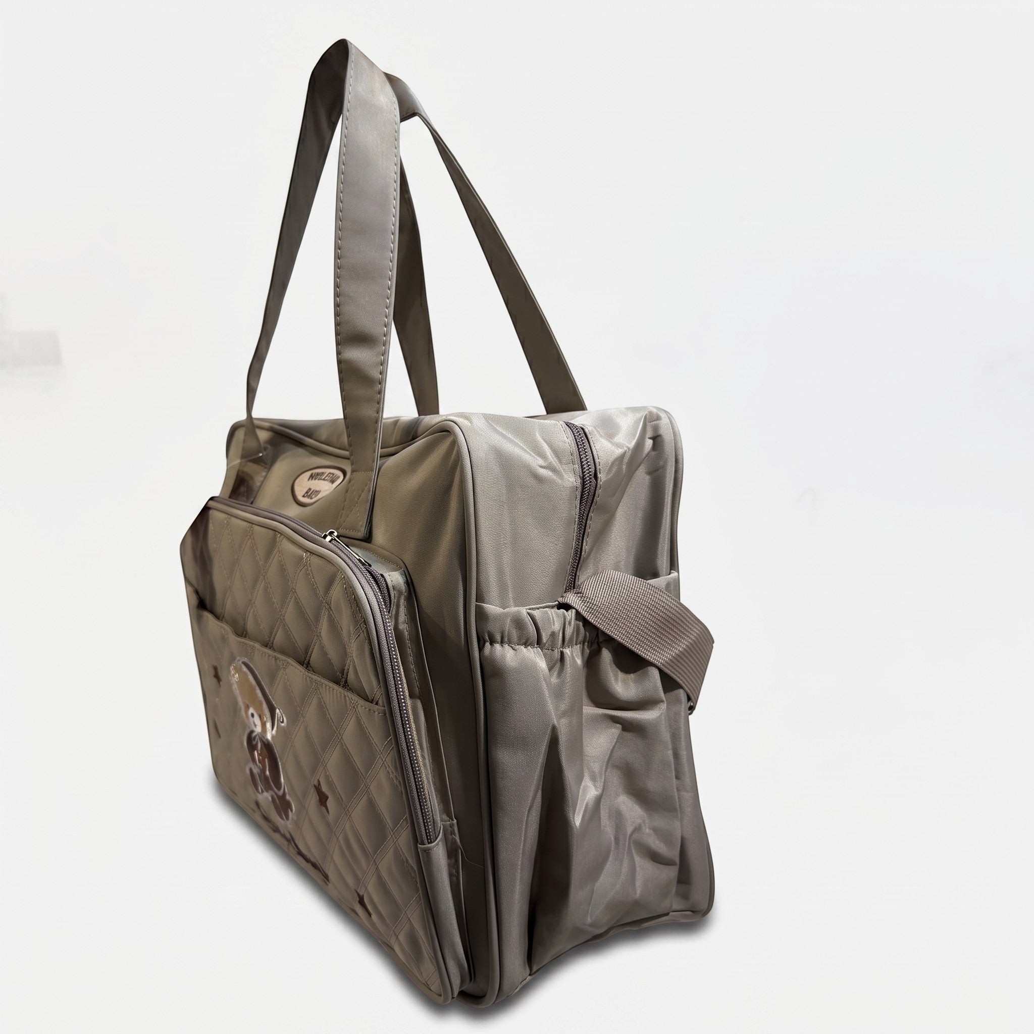 Faba Kids grey quilted baby diaper bag with an embroidered bear design, side pockets, and sturdy carry handles.